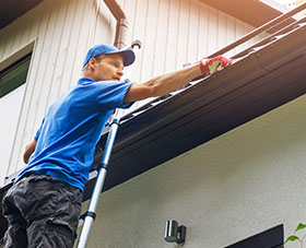 Man inspecting home gutters