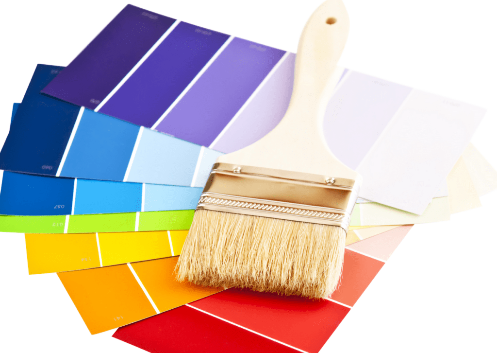 A paintbrush lies on top of a fan of colorful paint swatches, ranging from blues and greens to yellows, oranges, and reds.