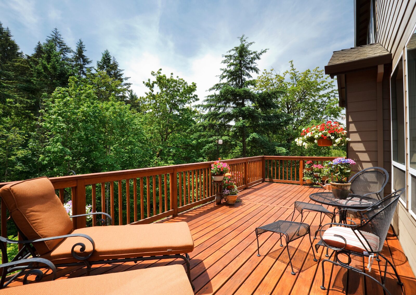 Beautifully painted deck with outdoor furniture and lush greenery, showcasing how to paint a deck for a stunning finish.