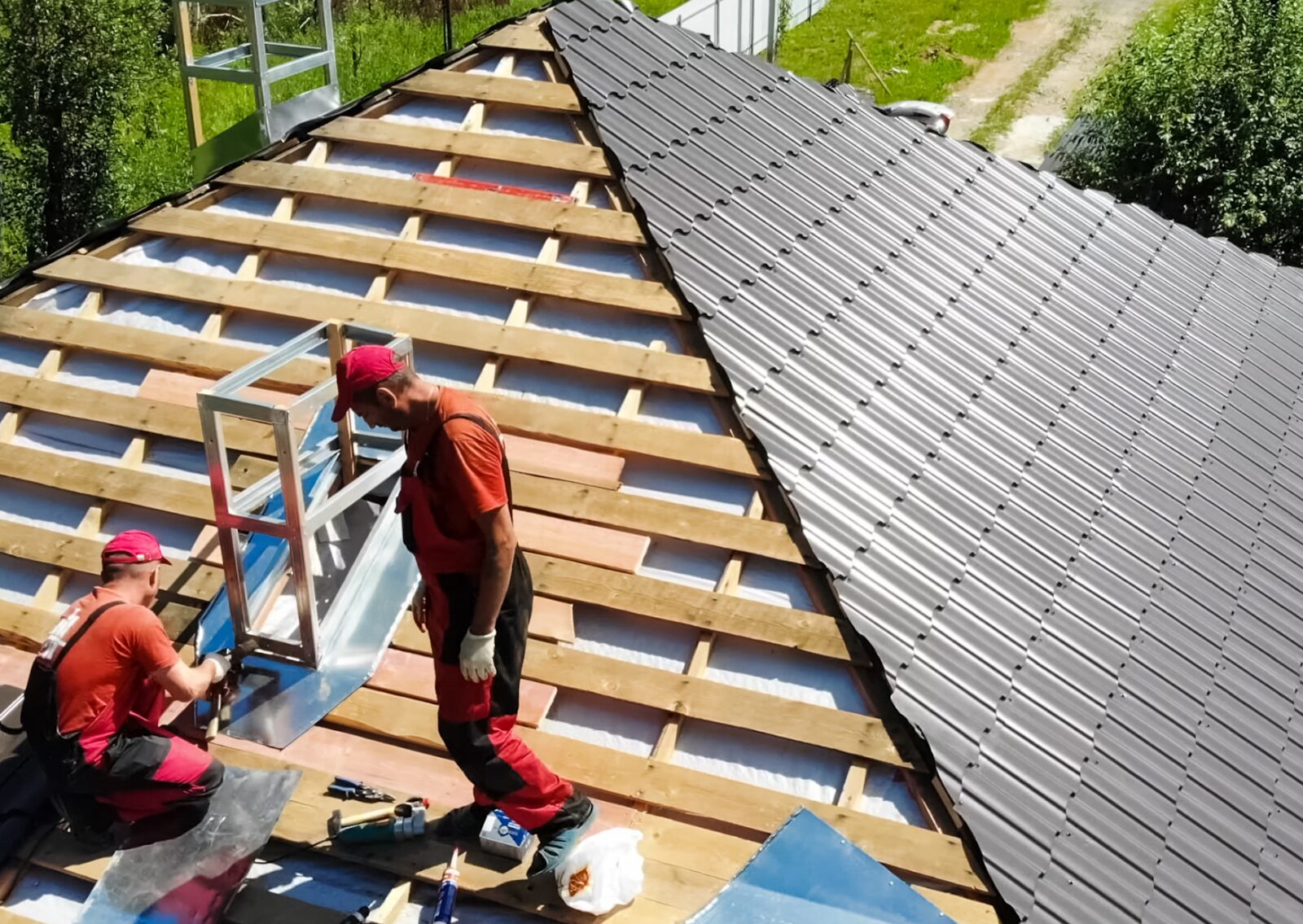 Two workers from a local roofing company installed new metal roofing sheets, showcasing high-quality construction.