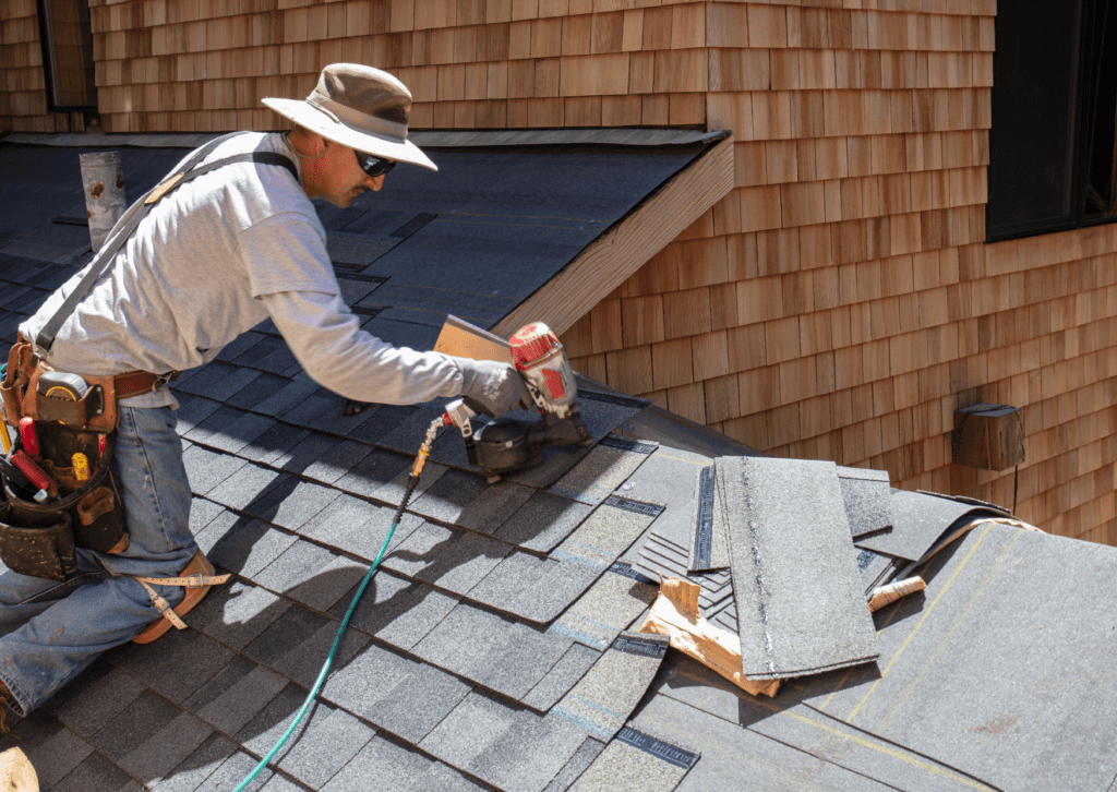 A skilled roofer from a premier roofing company installing shingles on a roof, ensuring top-quality craftsmanship.