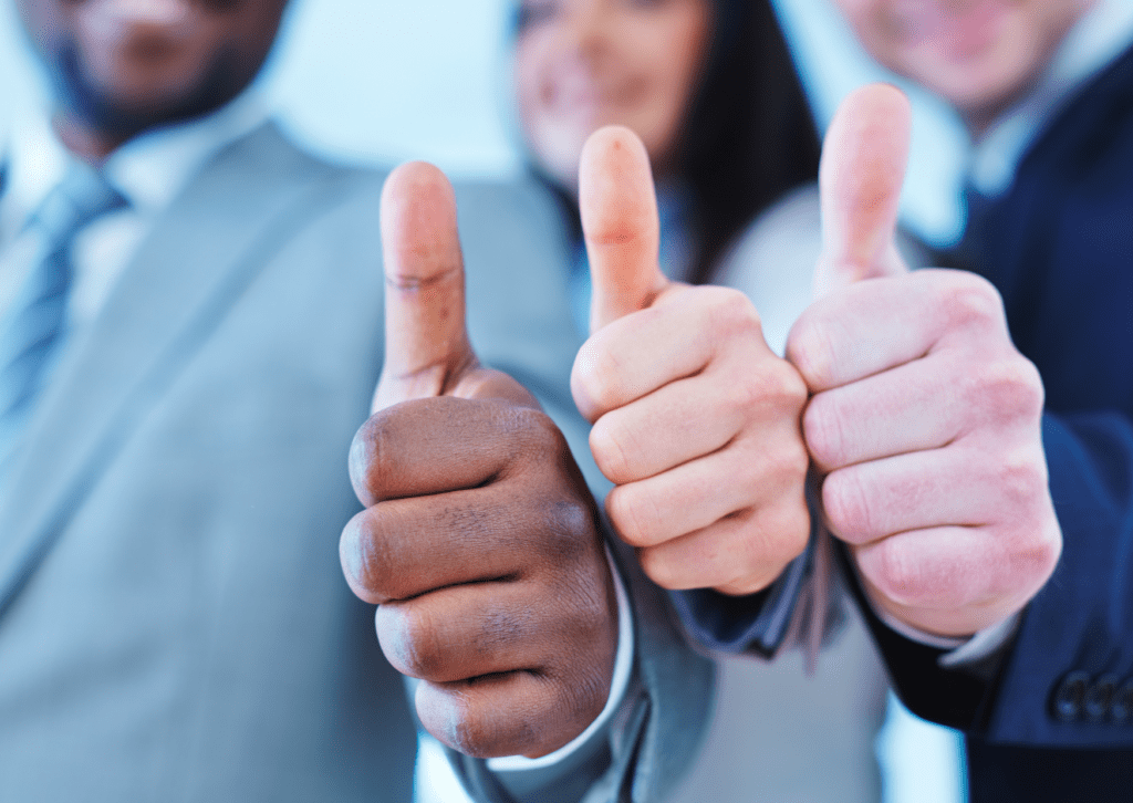 A diverse group of professionals gives a thumbs up, symbolizing approval, success, teamwork, and positive results.