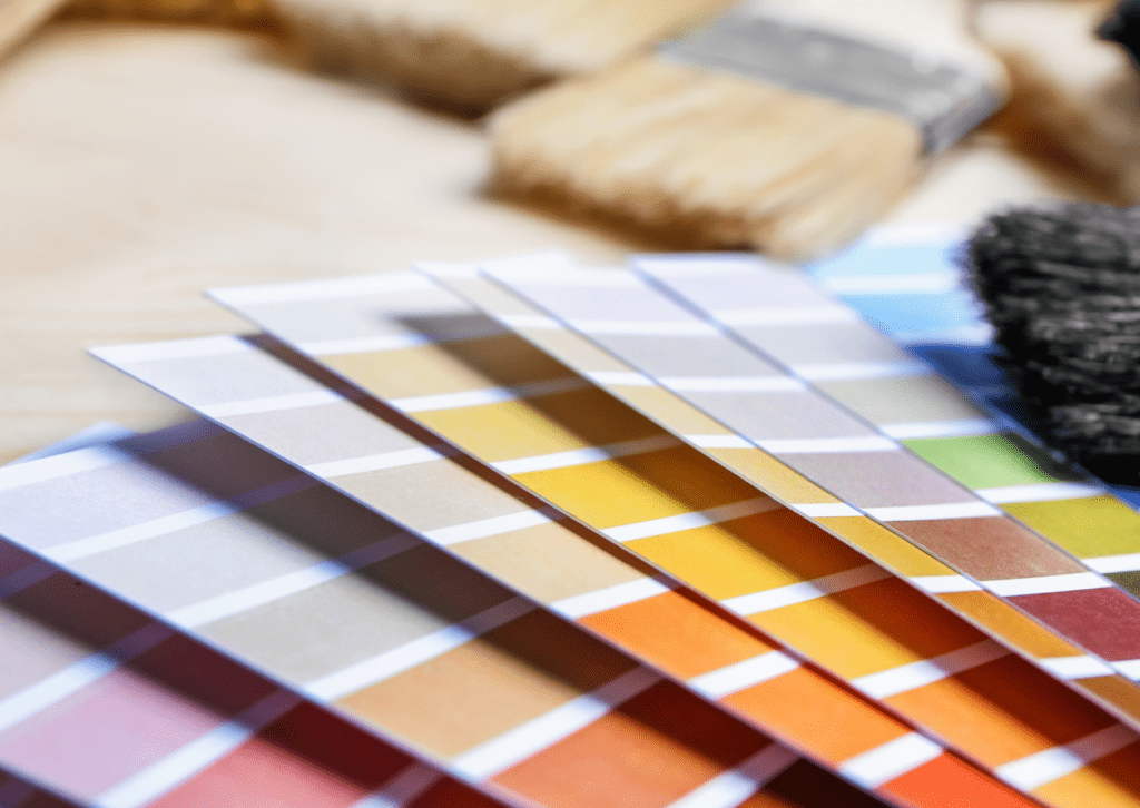 Paint color swatches and brushes. Learn how to select a paint color for your home with expert tips for a perfect finish.