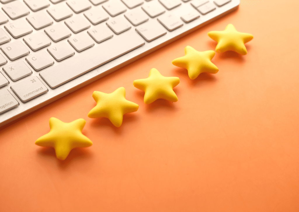 Five yellow stars are placed beside a keyboard, symbolizing a five-star online review and positive customer feedback.