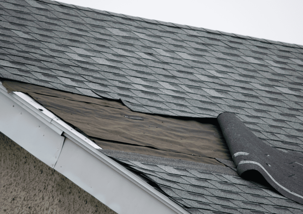 The roof with missing shingles showing damage and roof leakage, needing immediate repair to prevent further issues.