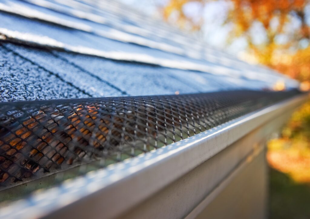 Close-up of a mesh gutter guard installed on a roof to prevent leaves and debris from clogging the rain gutter system.