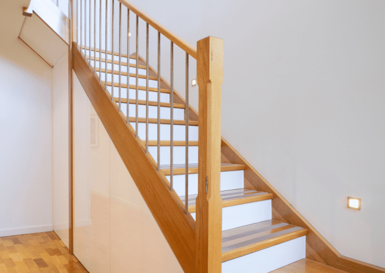 Wooden staircase with white risers and oak railing, a perfect example for paint for stairs projects.