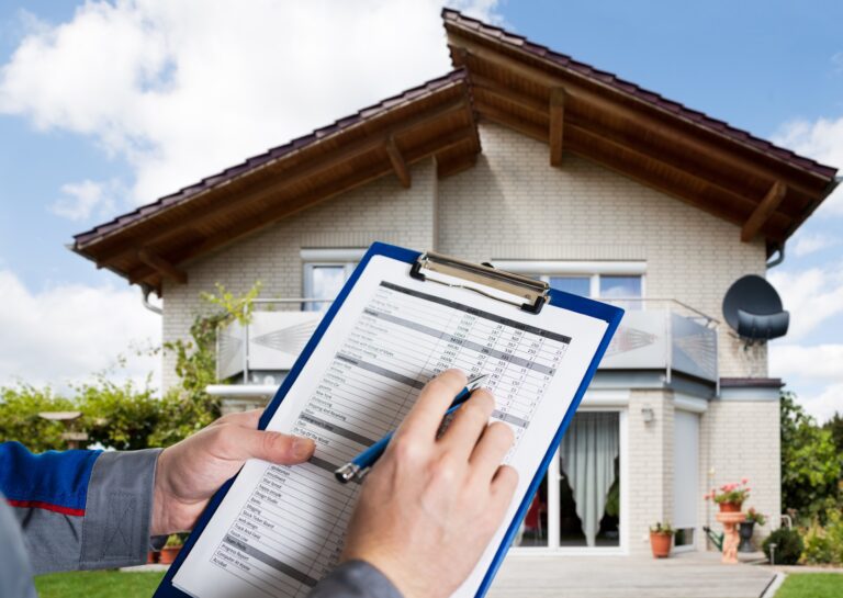 Close-up of a contractor holding a clipboard with a cost estimate in front of a modern two-story home.