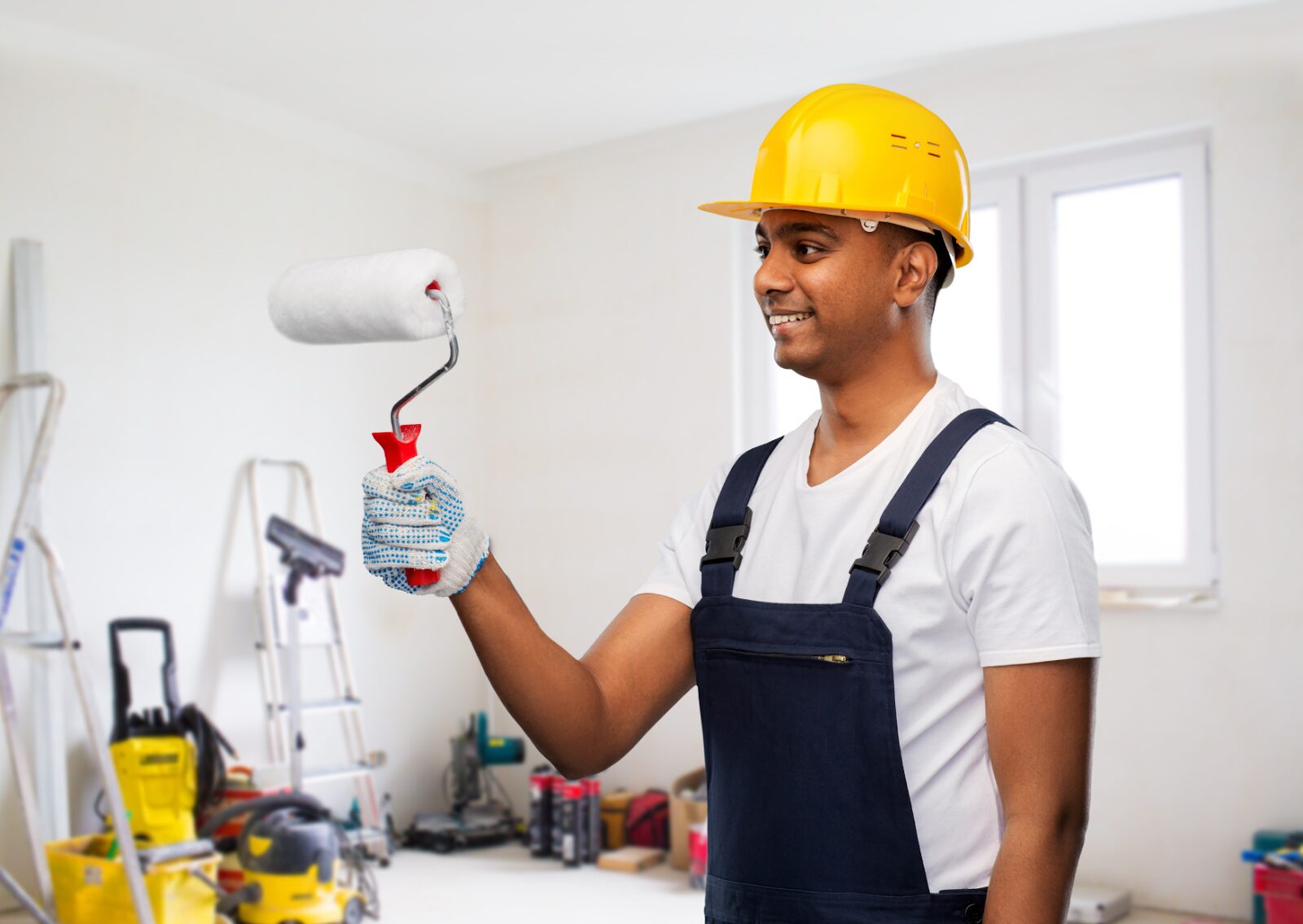 Residential painting contractors preparing to paint interior walls using a roller in a home renovation setting.